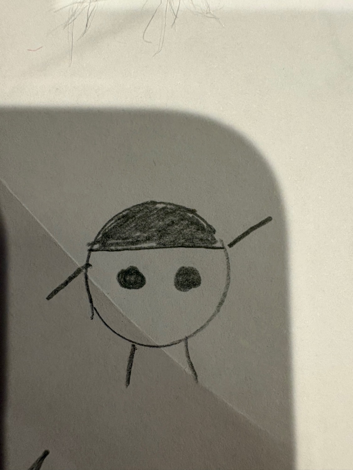The picture: a pencil close-up of Cokco - a round head, a solid grey top that is colour and not hair, two dot eyes, one arm up and one arm down
